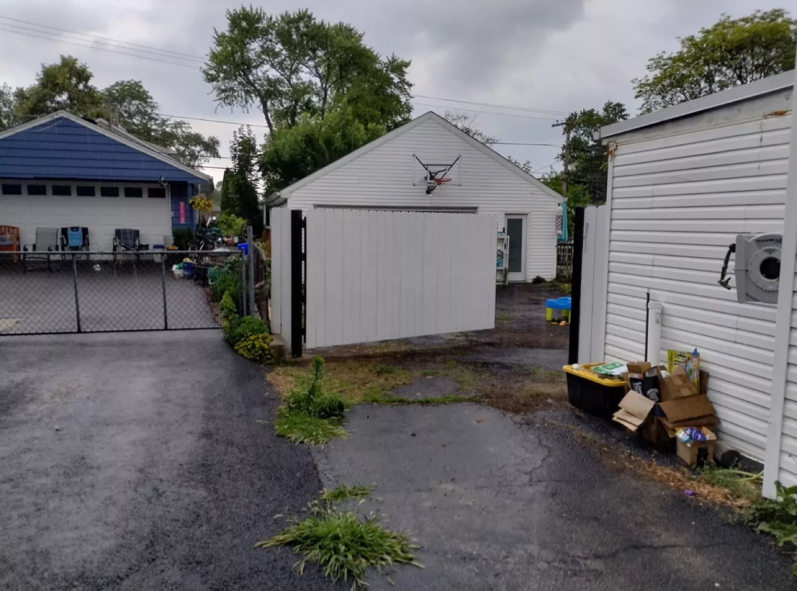 Large black-framed privacy gate installed across a residential driveway opening.