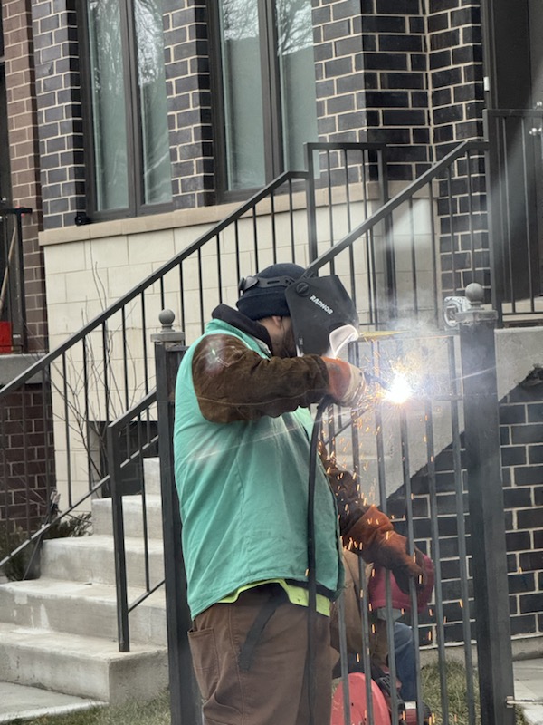 On-site welding during steel fence and gate line installation.