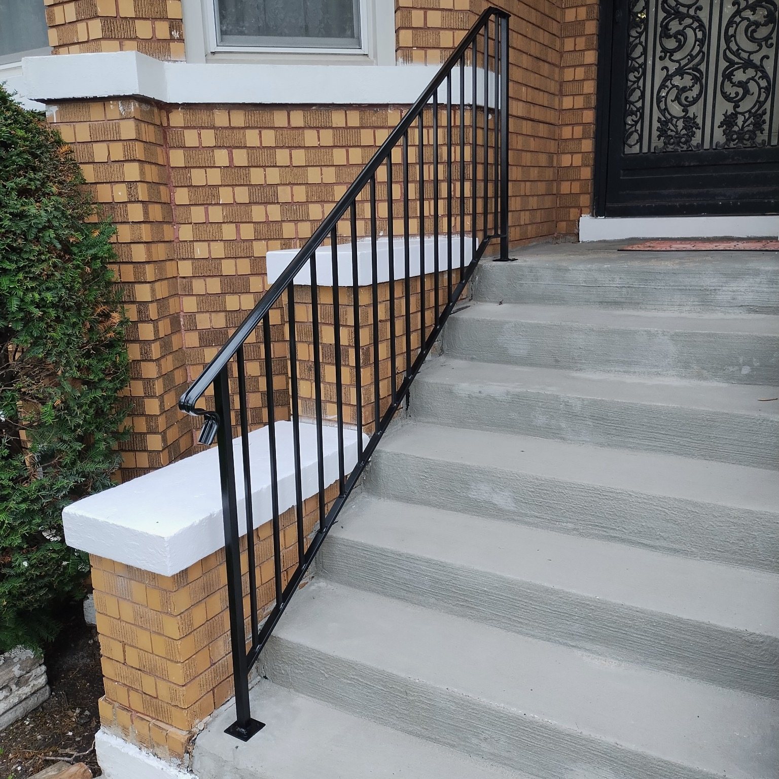 Finished black steel handrail on repaired Chicago front steps.