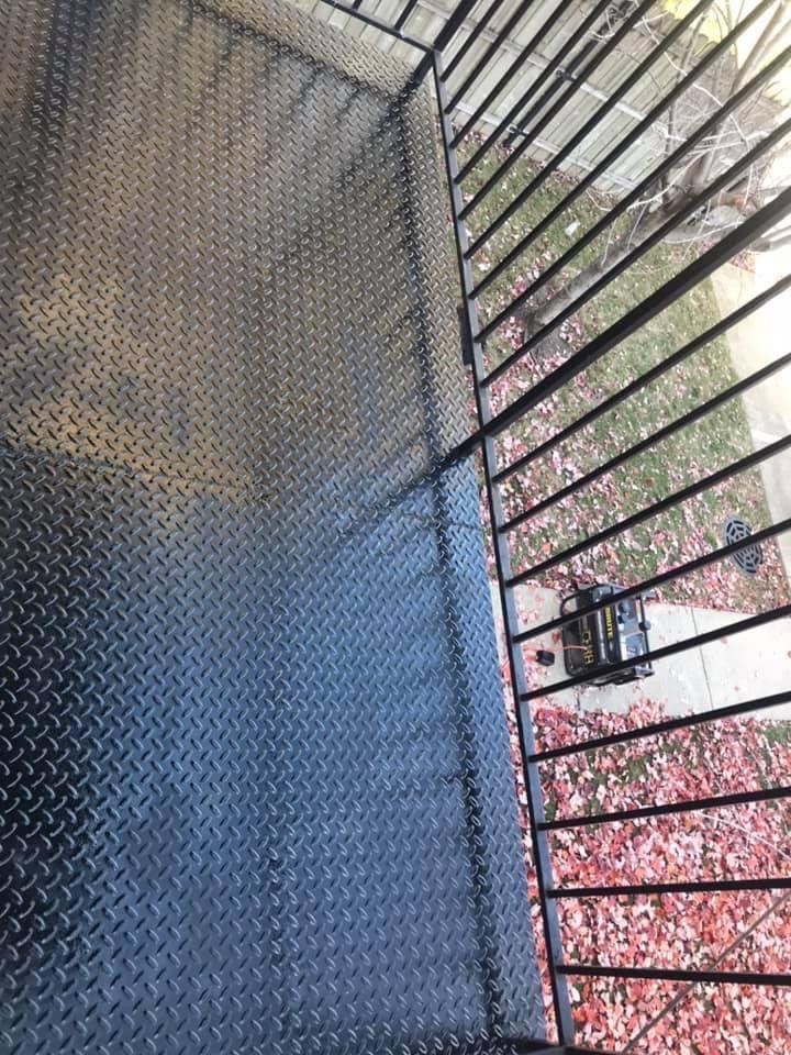 Recoated black exterior metal landing after rust repair prep.