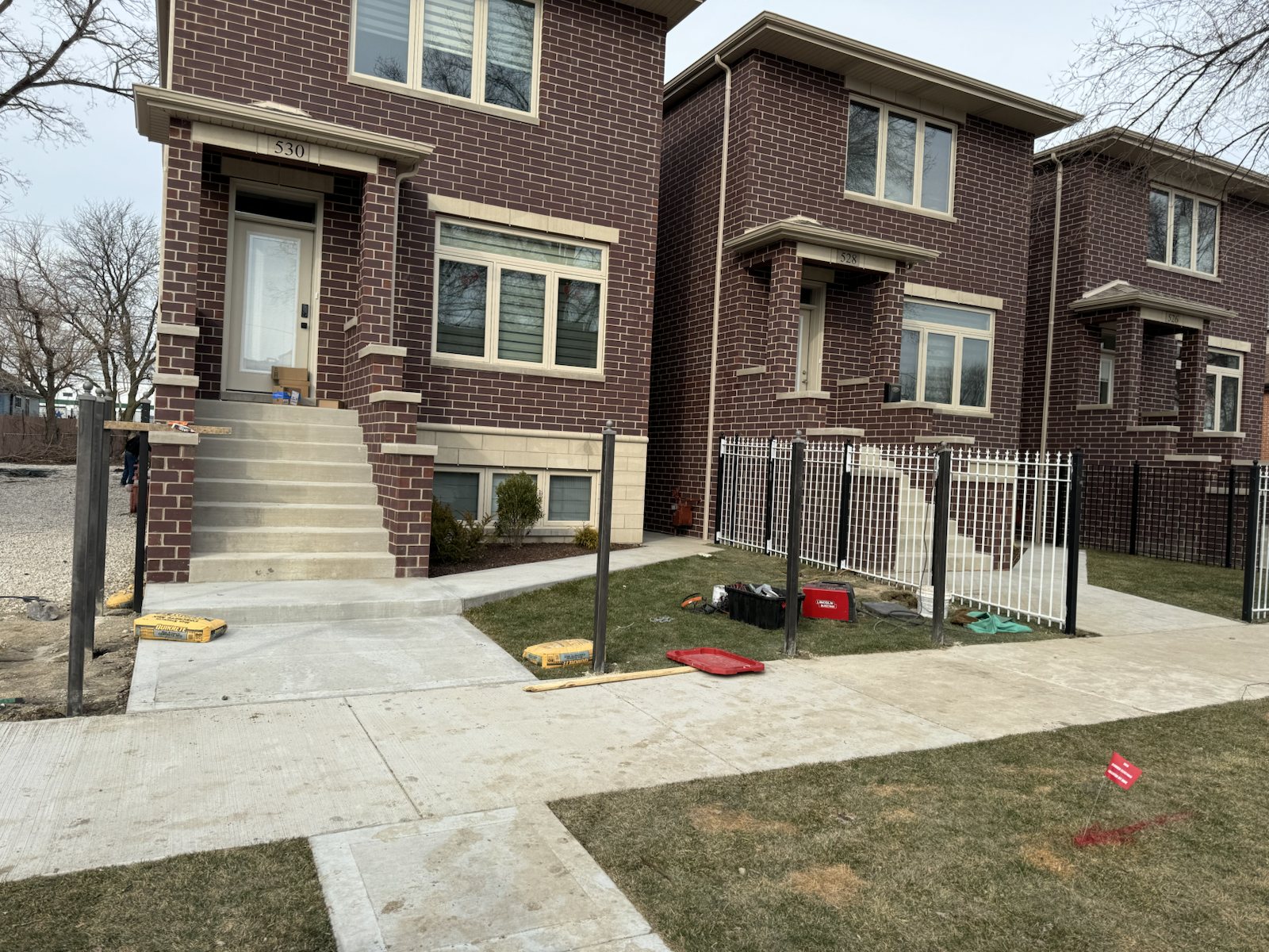 Metal fence posts laid out before final fence and railing installation.