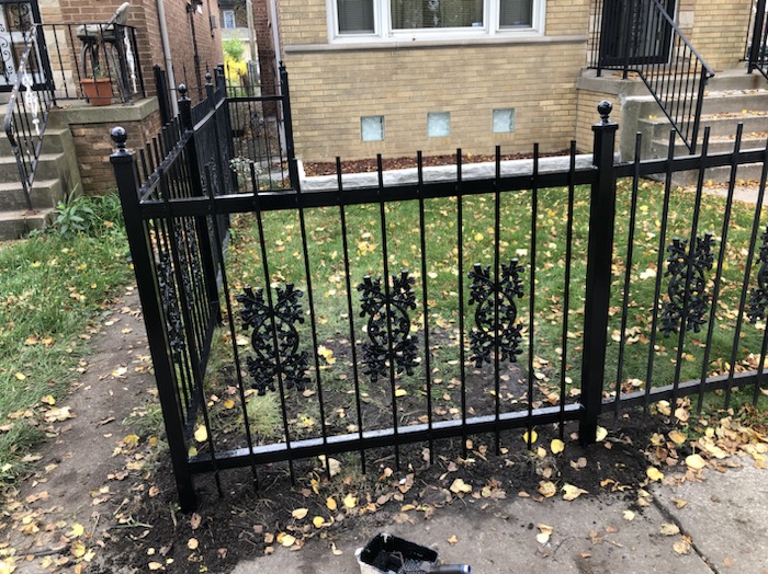 Finished ornamental steel fence panel with decorative inserts after installation.