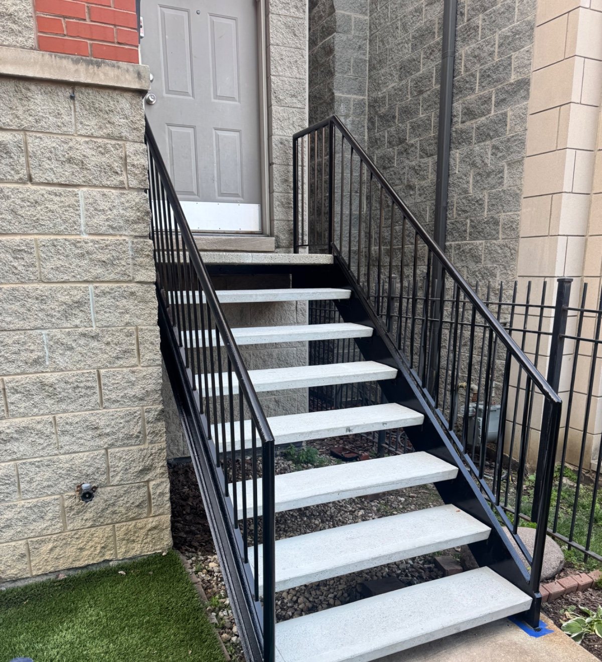 Finished black metal stair frame and railing after front-step repair.