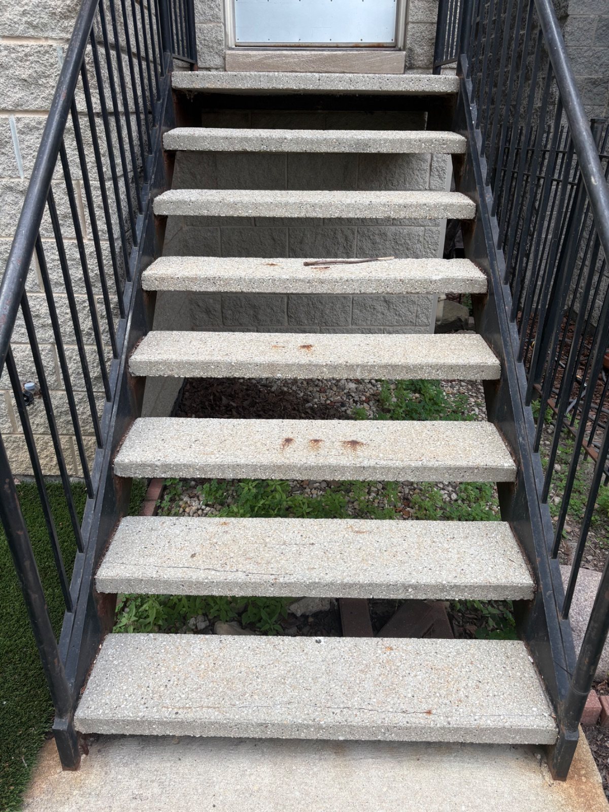 Rusted front-step steel frame and worn stair supports before repair.