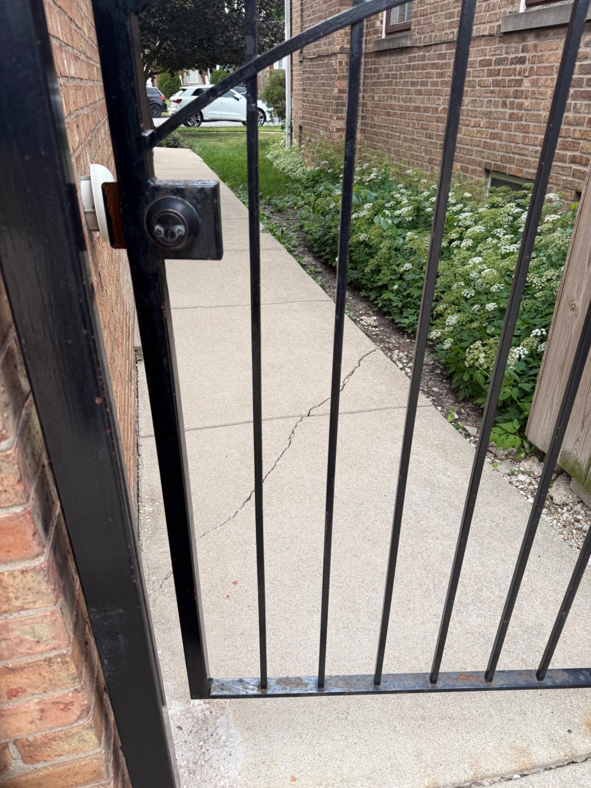 Metal gate that does not line up correctly with the lock before repair.