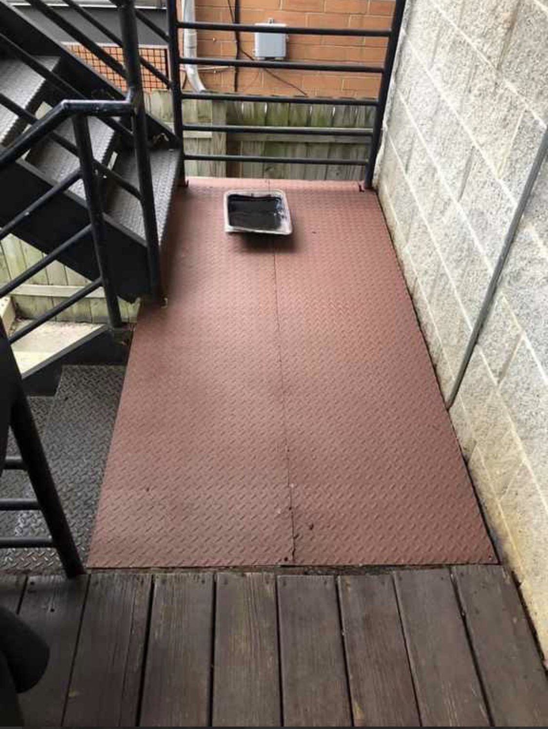 Repainted exterior metal landing surface after front-entry repair prep.