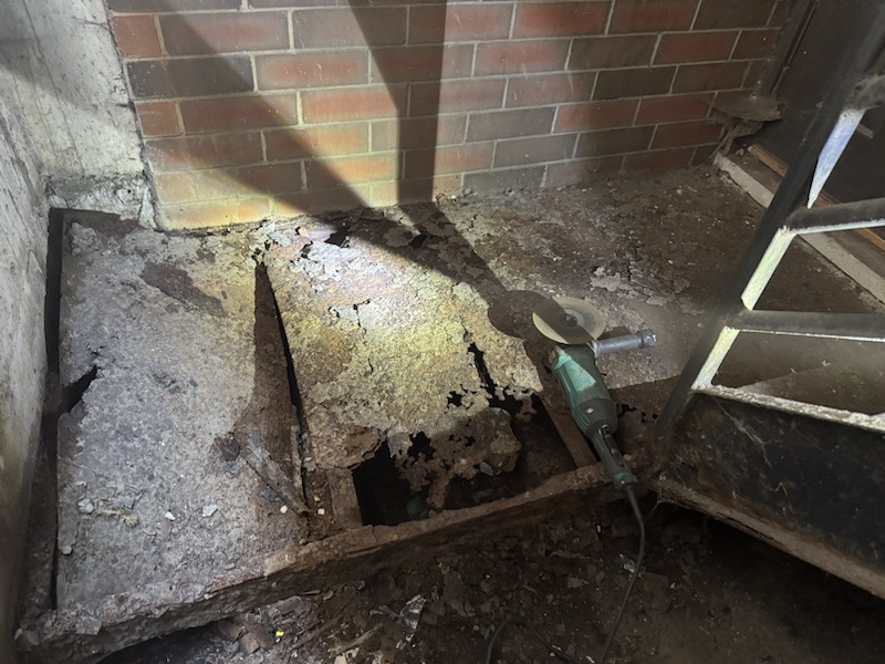 Before photo of a severely rusted steel landing with failing floor plate that needed replacement.