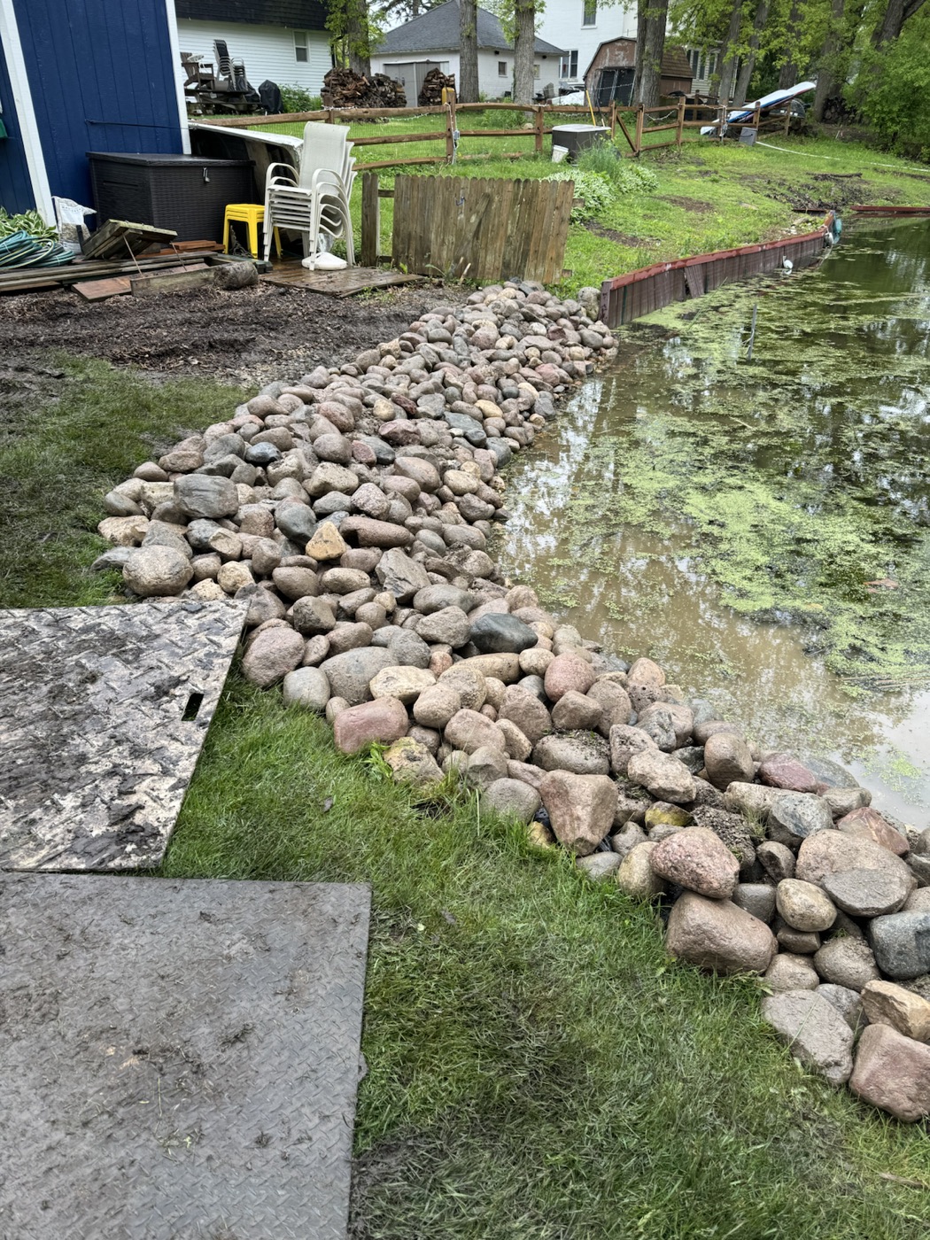Channel-side shoreline repair with rounded rip rap stone and water access.